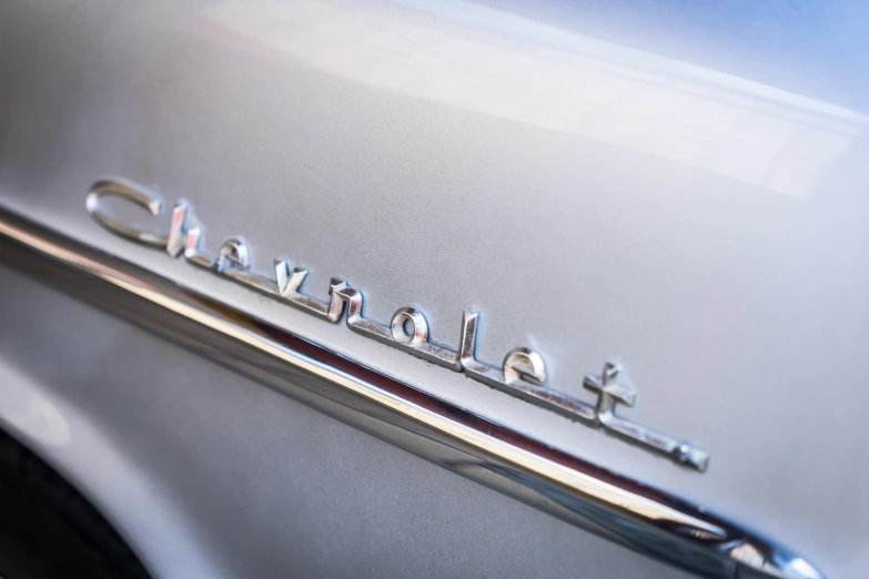 a close up of the emblem on a car, by Matt Cavotta, unsplash, 1957 chevrolet bel air, etched inscriptions, white pearlescent, pastel'