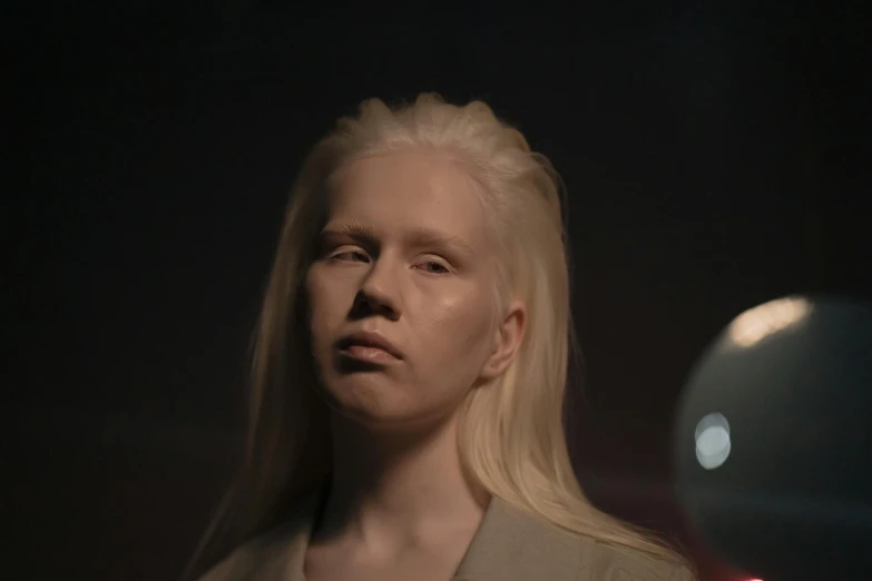 a woman with blonde hair standing in a dark room, inspired by Vanessa Beecroft, albino dwarf, on another planet, tv still, woman's face