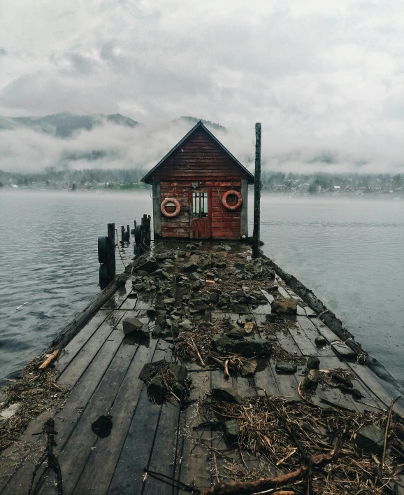 a red boathouse sitting on top of a wooden dock, an album cover, pexels contest winner, rainy environment, foggy dystopian world, 500px photos, a photograph of a rusty