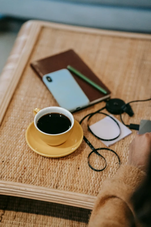 a person sitting at a table with a cup of coffee, cable plugged in, charcoal and yellow leather, promo image, instagram picture