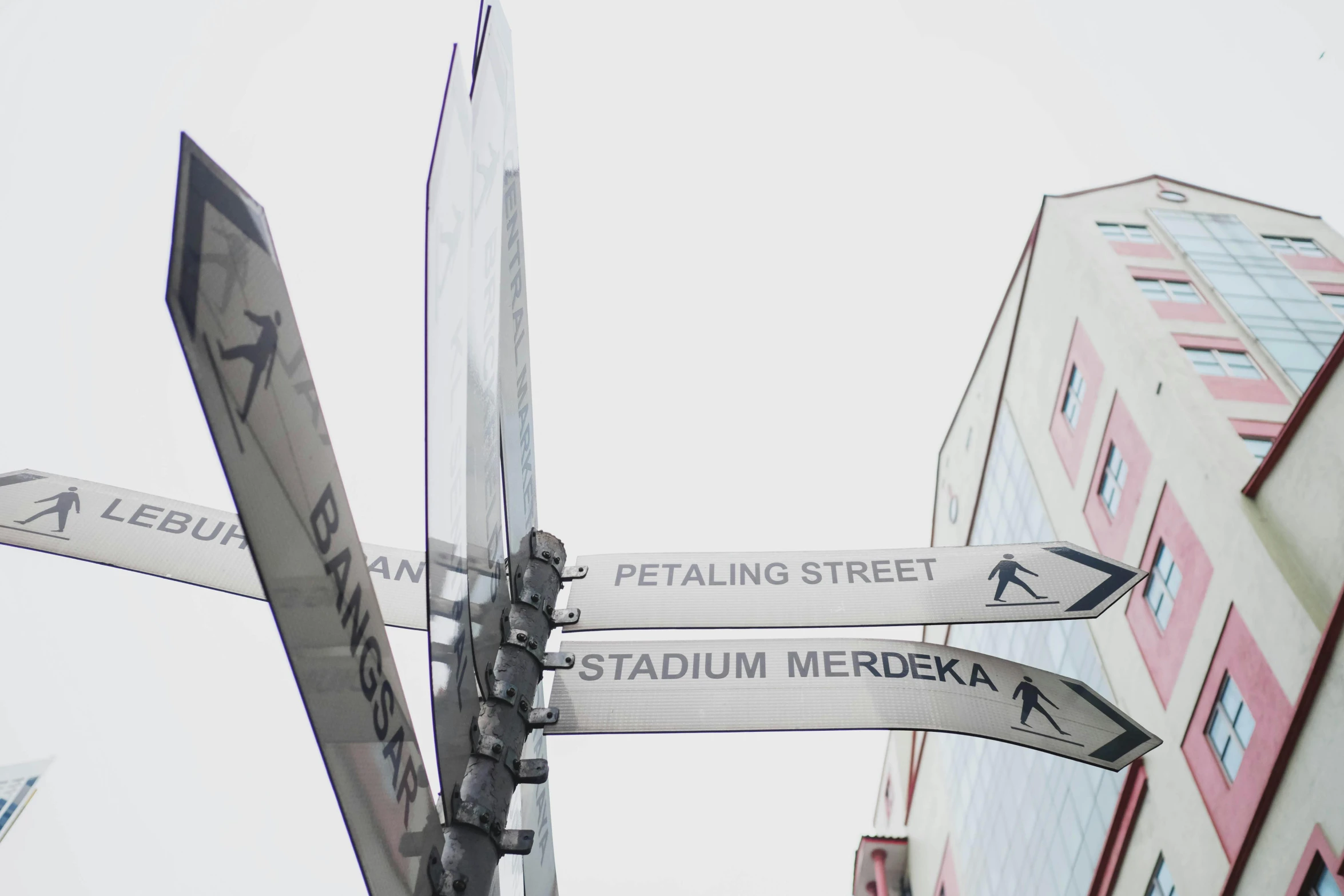 a close up of a street sign with buildings in the background, inspired by Hans Mertens, pexels contest winner, street art, bjarke ingels, kuala lumpur, stadium, official store photo