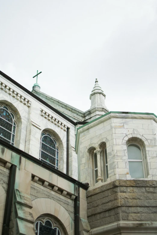 a tall building with a clock on top of it, a statue, inspired by Jesús Mari Lazkano, romanesque, white church background, rhode island, many large green windows, close-up from above