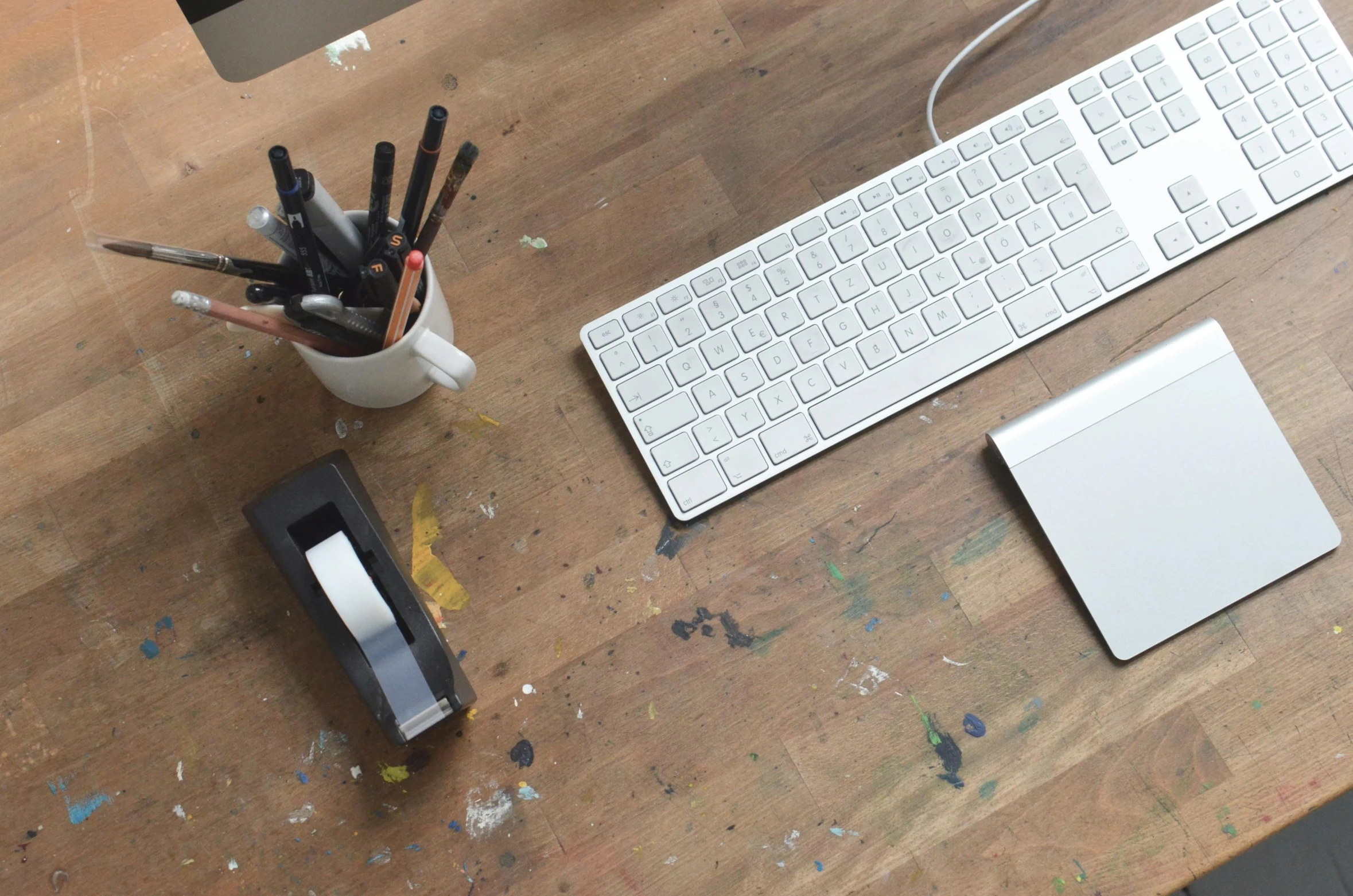 a desktop computer sitting on top of a wooden desk, unsplash, swiping brushwork, 9 9 designs, apartment of an art student, white finish