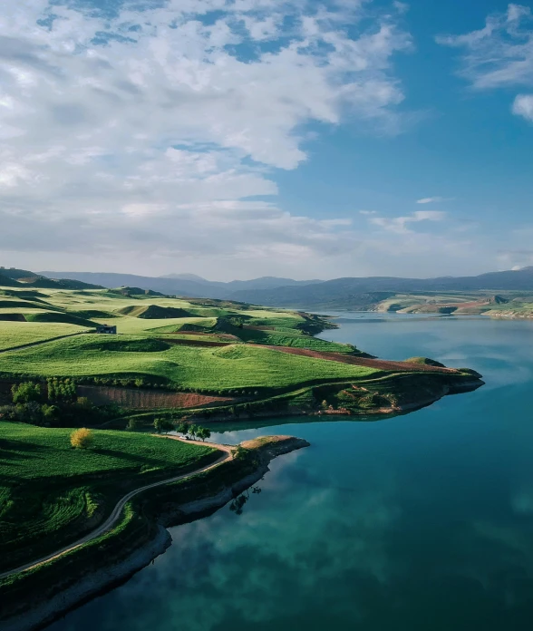 a large body of water surrounded by green hills, pexels contest winner, hurufiyya, beautiful composition 3 - d 4 k, farming, slightly tanned, cinematic morning light