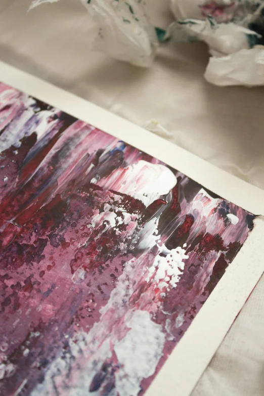 a close up of a piece of art on a table, an acrylic painting, unsplash, abstract art, purple trees, printed on paper, dark chocolate painting, painted with colour on white