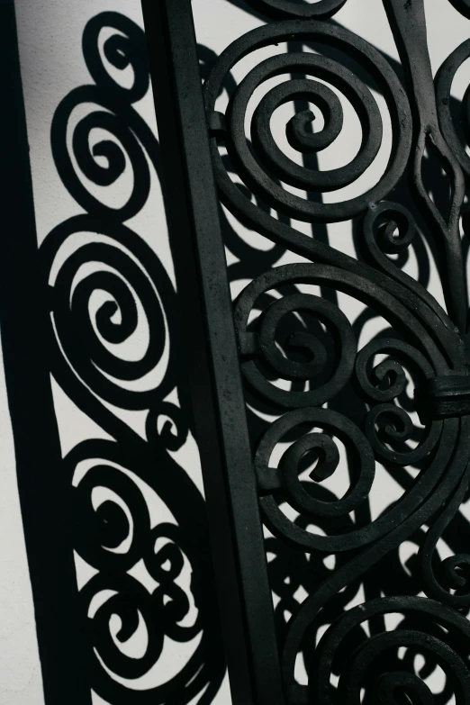 a clock that is on the side of a building, by Carey Morris, unsplash, arts and crafts movement, iron gate door texture, swirls, black lacquer, detail structure