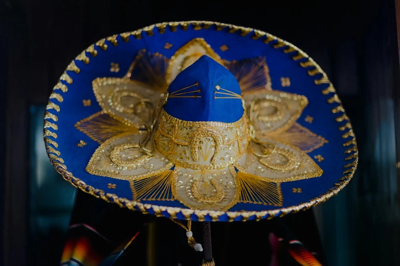 a blue sombren sitting on top of a table, pexels contest winner, rasquache, sombrero, ornate with gold trimmings, lit from the side, detaild
