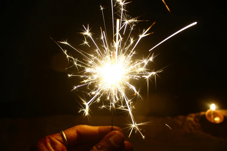 a person holding a sparkler in their hand, magnesium, thumbnail, spangle