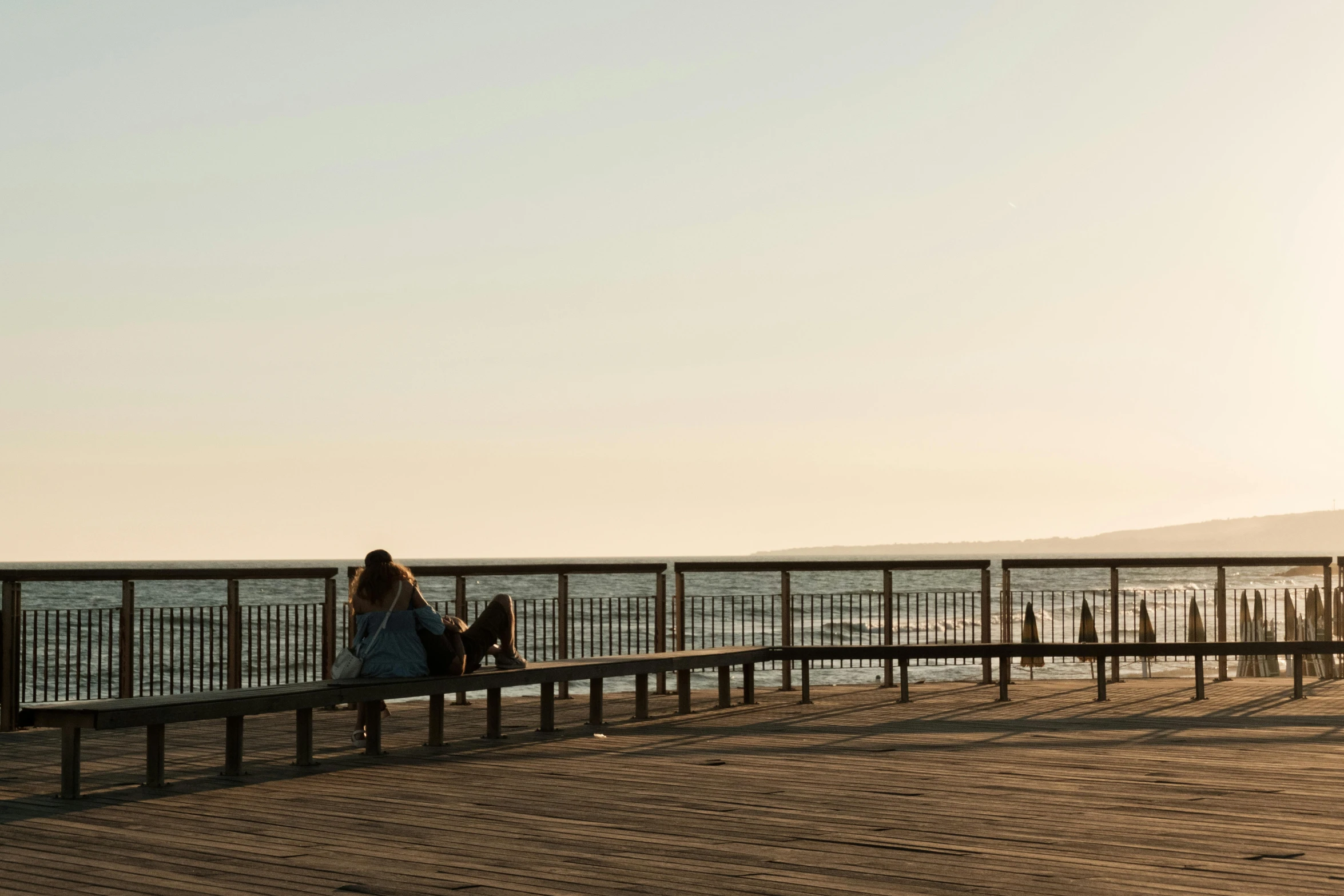 a couple of people that are sitting on a bench, pexels contest winner, golden hour in pismo california, panoramic view of girl, minimalist rule of thirds, brown