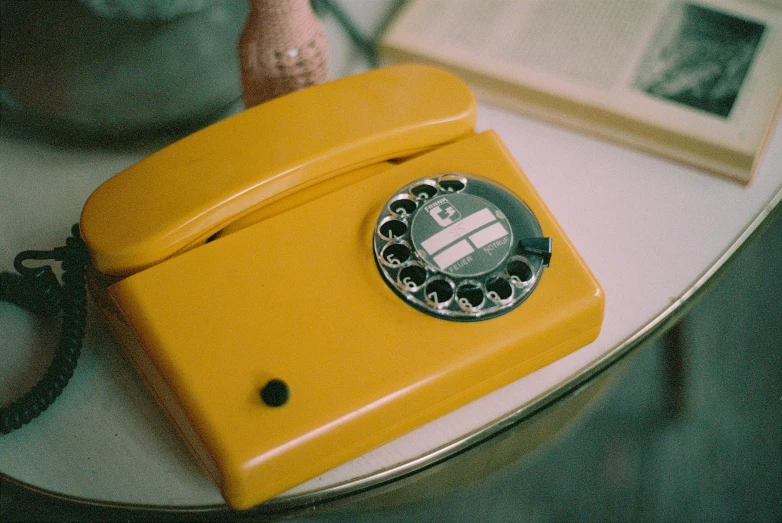 a yellow telephone sitting on top of a table, by Wes Anderson, unsplash, 🦩🪐🐞👩🏻🦳, 70s photo, the ring, homemade