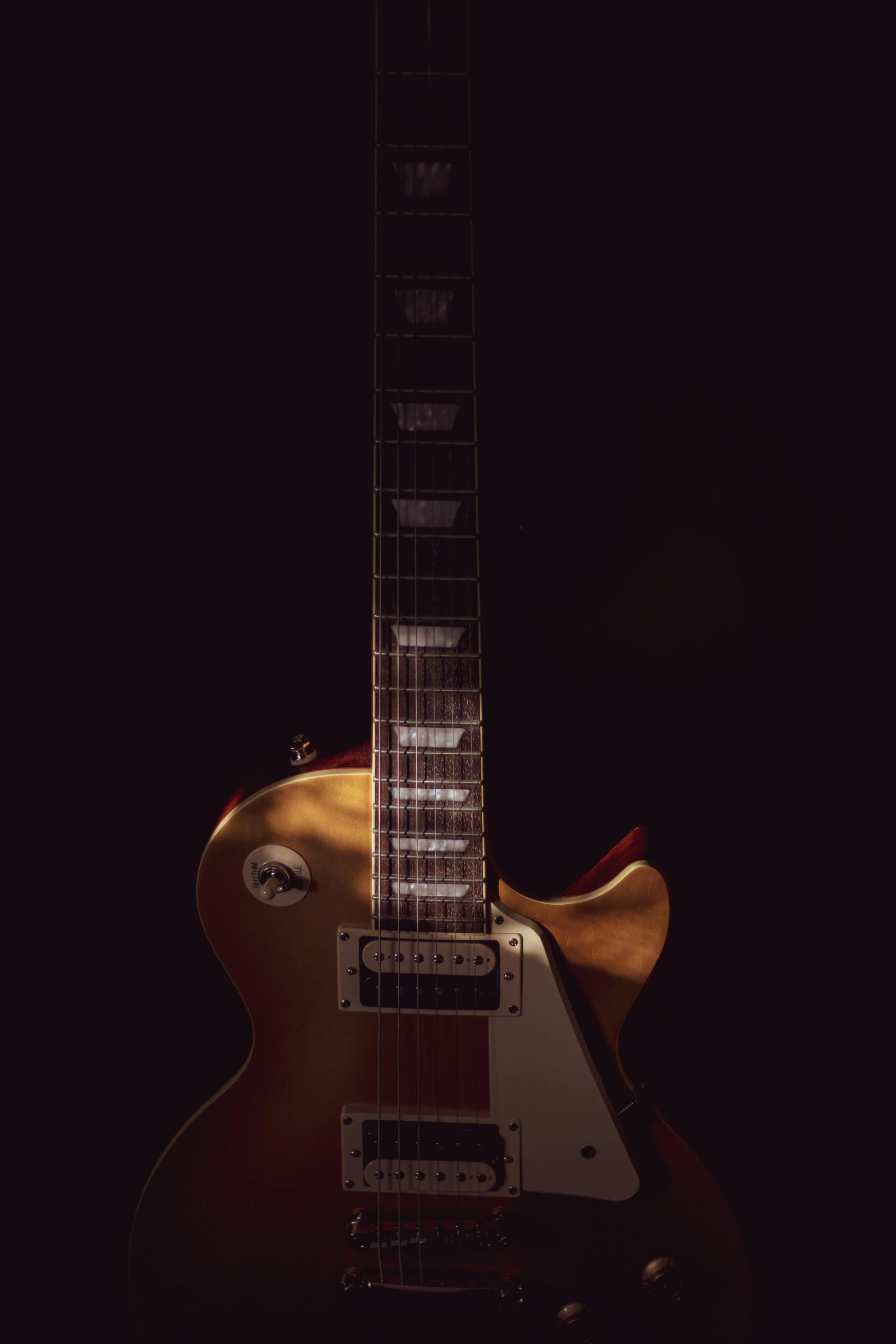 a close up of a guitar in a dark room, an album cover, by Gavin Nolan, pexels contest winner, photorealism, gold skin, toy photography, plain background, at nighttime