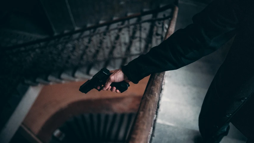 a person holding a gun in their hand, by Adam Marczyński, pexels contest winner, coming down the stairs, instagram post, teaser, game ready