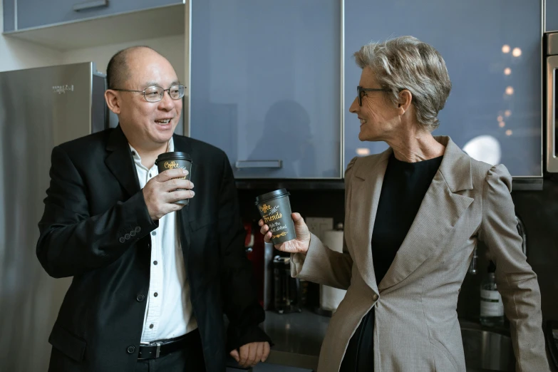 a man and a woman standing in a kitchen, inspired by Heinz Edelman, pexels contest winner, antipodeans, holding a boba milky oolong tea, wearing a suit and glasses, zeen chin and farel dalrymple, a man wearing a black jacket