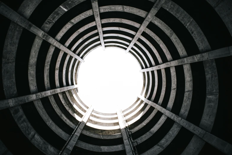 a black and white photo of a circular structure, an album cover, pexels contest winner, brutalism, ventilation shafts, alessio albi, view from below, luminous black hole portal