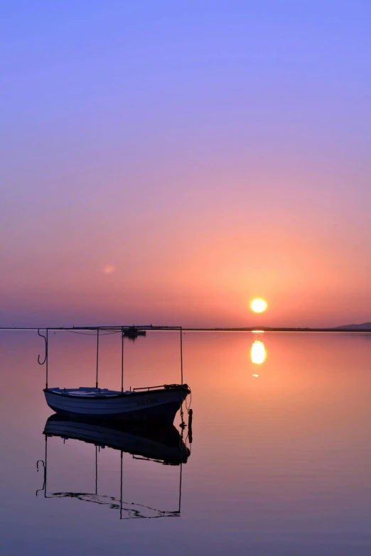 a boat sitting on top of a body of water, pexels contest winner, romanticism, sunrise colors, afar, reflective water, greece