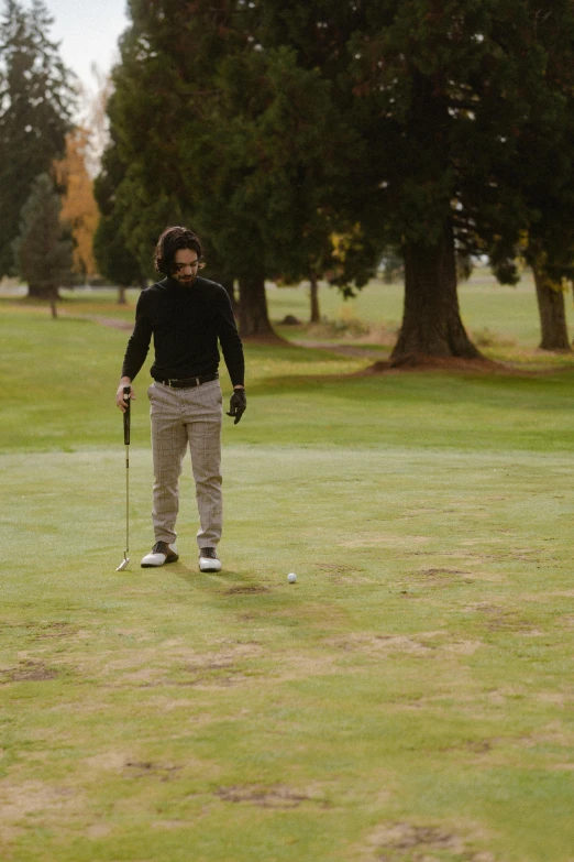 a man standing on top of a green golf course, an album cover, unsplash, low quality footage, mid shot, mid fall, launching a straight ball