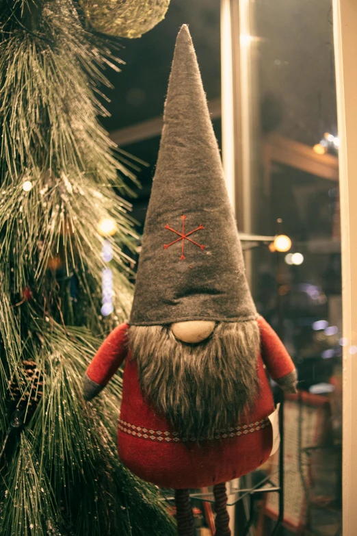 a christmas gnome hanging from a christmas tree, by Jaakko Mattila, pexels contest winner, folk art, gray beard, plush toy, located in a wizard's shop, looking smug