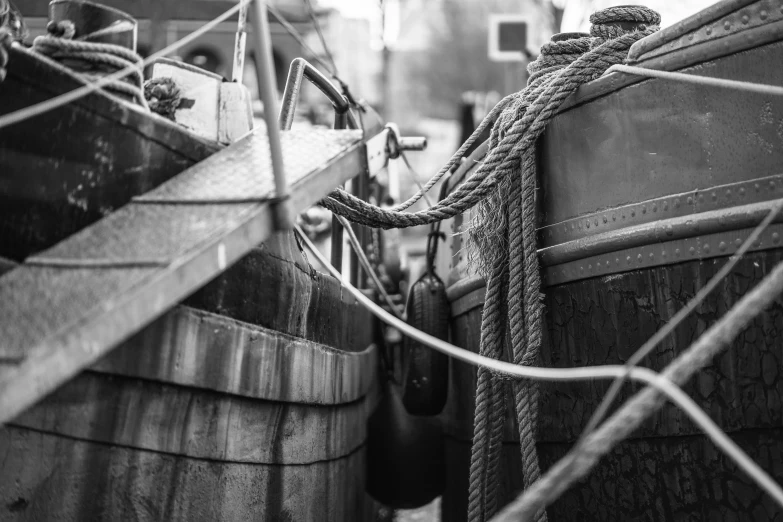 a couple of wooden barrels sitting next to each other, a black and white photo, by Adam Marczyński, sails and masts and rigging, machinery and wires, close - up photo, evan lee