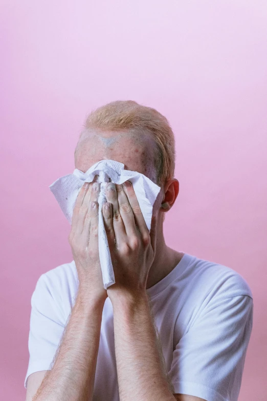 a man covers his face with a napkin, an album cover, pexels contest winner, aestheticism, albino skin, bruised, pastel colored, cysts