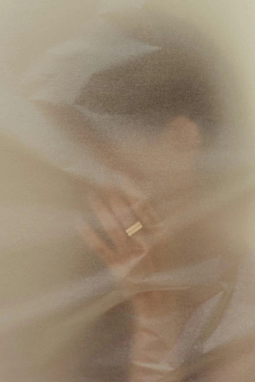 a blurry image of a man talking on a cell phone, an album cover, by Anna Füssli, conceptual art, gold silk, ring, beige mist, ignant