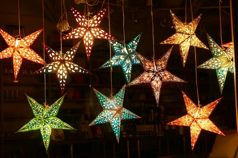 a bunch of star shaped lights hanging from a ceiling, by Julia Pishtar, pexels, folk art, lantern light, tropical lighting, floor lamps, northern star at night