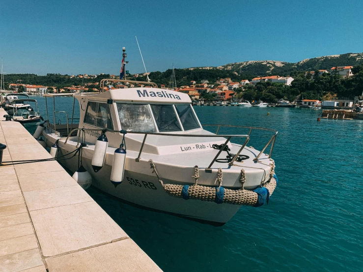 a boat that is sitting in the water, croatian coastline, docked at harbor, profile image, square