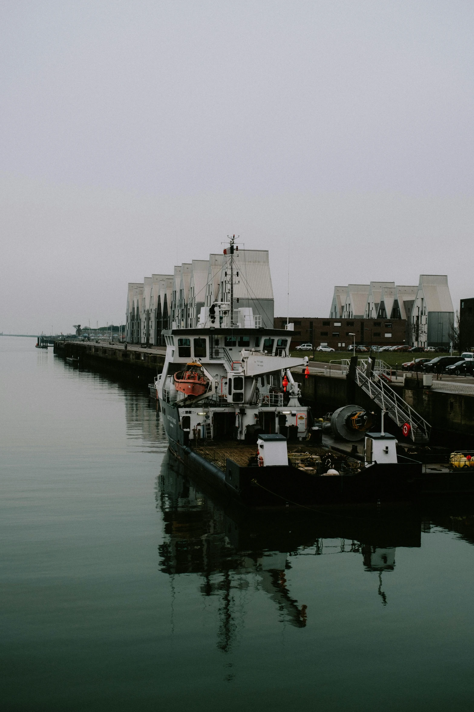 a couple of boats that are sitting in the water, industrial aesthetic, gray sky, high res photograph, 2019 trending photo