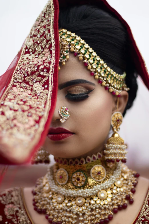 a woman wearing a red and gold bridal, inspired by Li Di, pexels, silver jewellery, very expressive, breathtaking realistic, vibrant scene