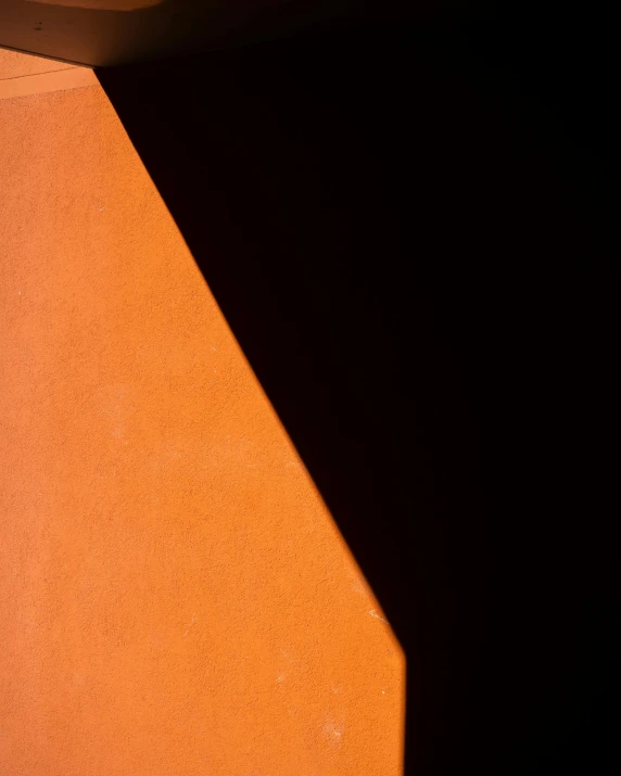 a close up of a wall with a clock on it, an abstract sculpture, by Doug Ohlson, unsplash, postminimalism, dark orange, shadow gradient, large triangular shapes, terracotta