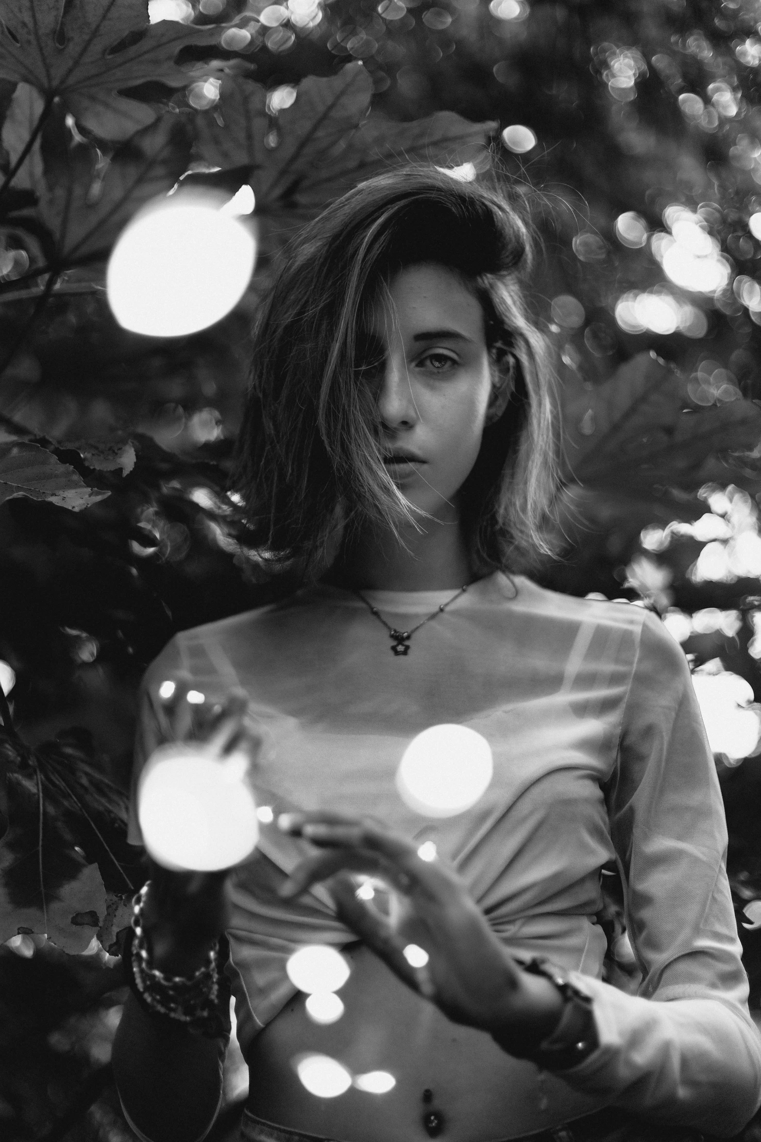 a black and white photo of a woman holding a crystal ball, inspired by Elsa Bleda, tumblr, in a candy forest! at night, portrait of ana de armas, androgynous face, on a tree