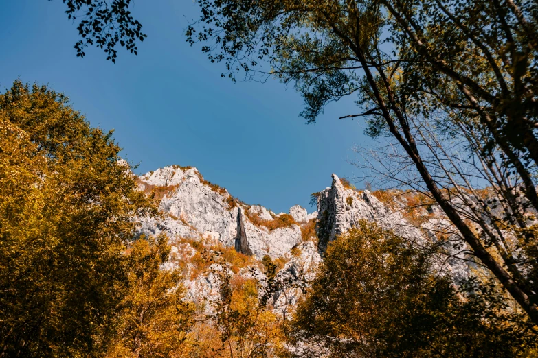 a mountain with trees in the foreground and a blue sky in the background, by Tobias Stimmer, les nabis, st cirq lapopie, jovana rikalo, thumbnail, fall season