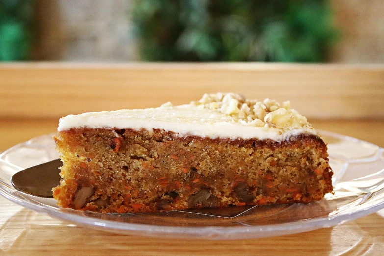 a piece of carrot cake on a glass plate, by Nicolette Macnamara, video, rear facing, wooden, healthy