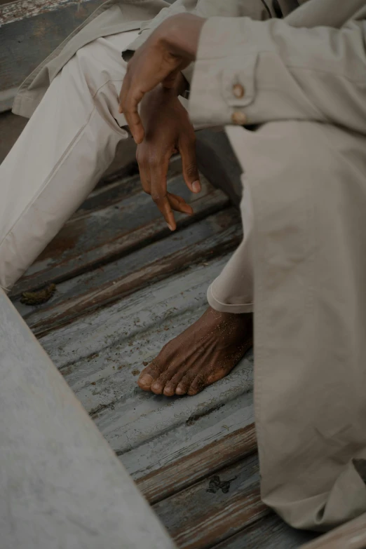 a man sitting on the steps of a train, inspired by Ismail Gulgee, pexels contest winner, renaissance, exposed toes, kano), holes in a religious man, grey skin