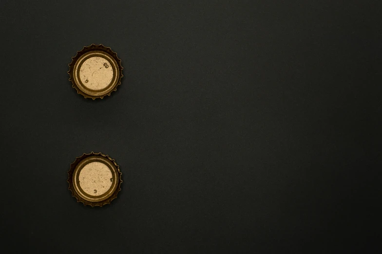 a couple of clocks sitting on top of a black wall, an album cover, by Andries Stock, trending on unsplash, minimalism, surface with beer-texture, golden miniatures, ignant, brown holes