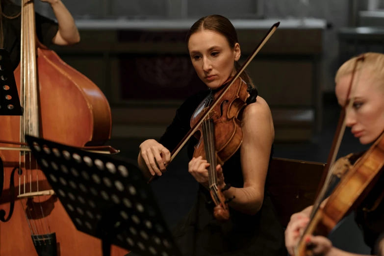 a group of women playing musical instruments in a room, an album cover, by Arabella Rankin, unsplash, baroque, portrait image, performing on stage, close-up photograph, violin