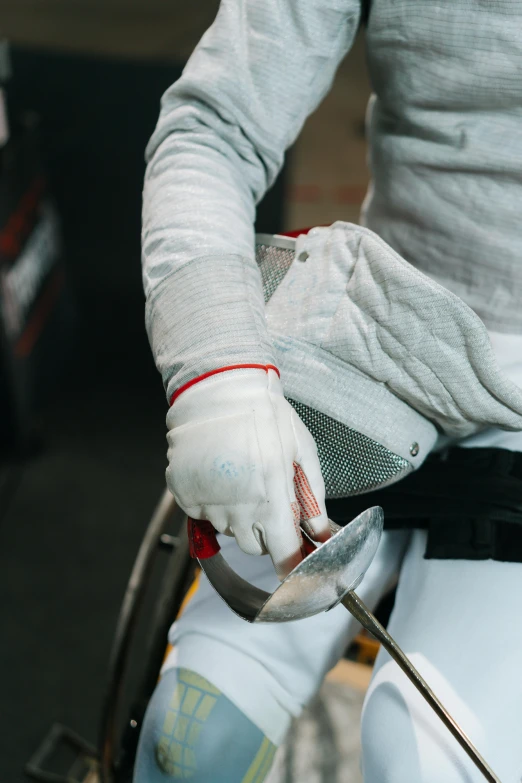 a close up of a person holding a fencer's hand, sitting in a wheelchair, full body armour, grey, white