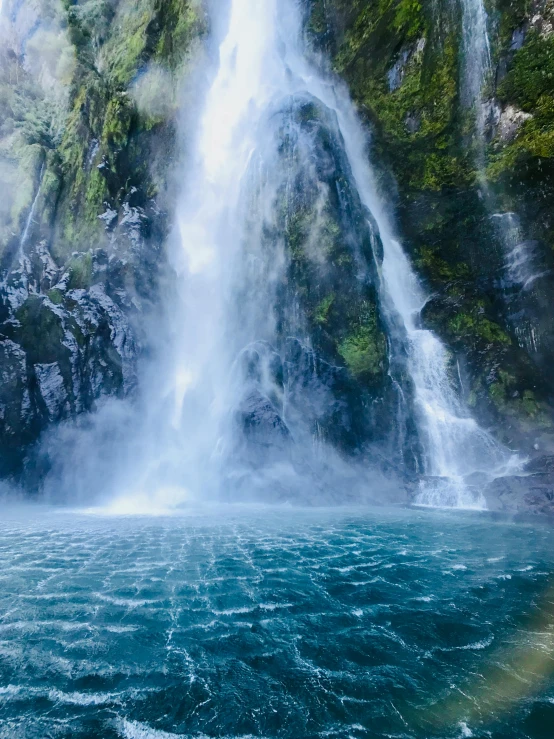 a waterfall with a rainbow in the middle of it, sapphire waters below, maori, 2022 photograph, 4k image