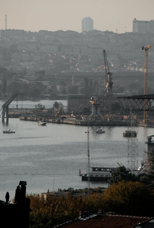 a large body of water with a city in the background, massive construction machines, dark and misty, istanbul, demur