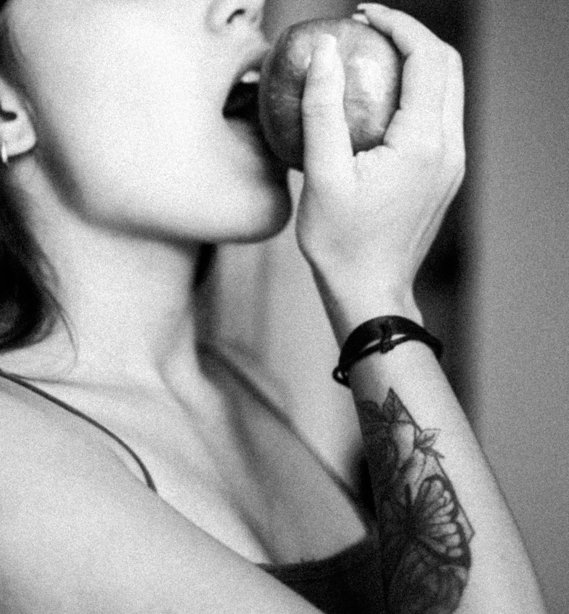 a black and white photo of a woman eating an apple, a tattoo, tumblr, kiss, 🐿🍸🍋, ?black apples, an apple