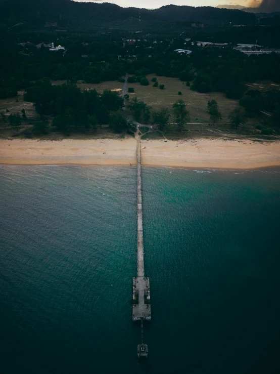 a long pier in the middle of a body of water, by Adam Marczyński, pexels contest winner, hurufiyya, australian beach, looking down on the camera, bad light, today\'s featured photograph 4k