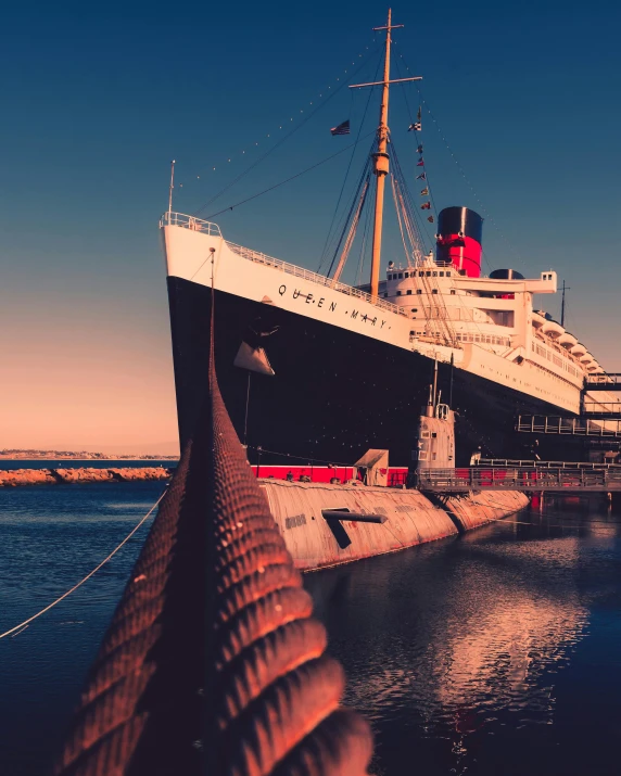 a large boat sitting on top of a body of water, a colorized photo, pexels contest winner, modernism, queen elizabeth, giant submarine, thumbnail, vintage aesthetic