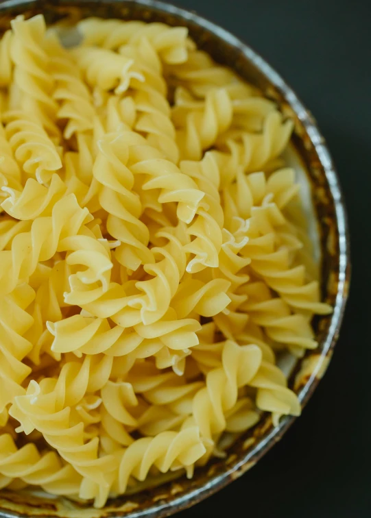 a bowl filled with pasta sitting on top of a table, cleanest image, zig zag, medium close up, yellow aureole