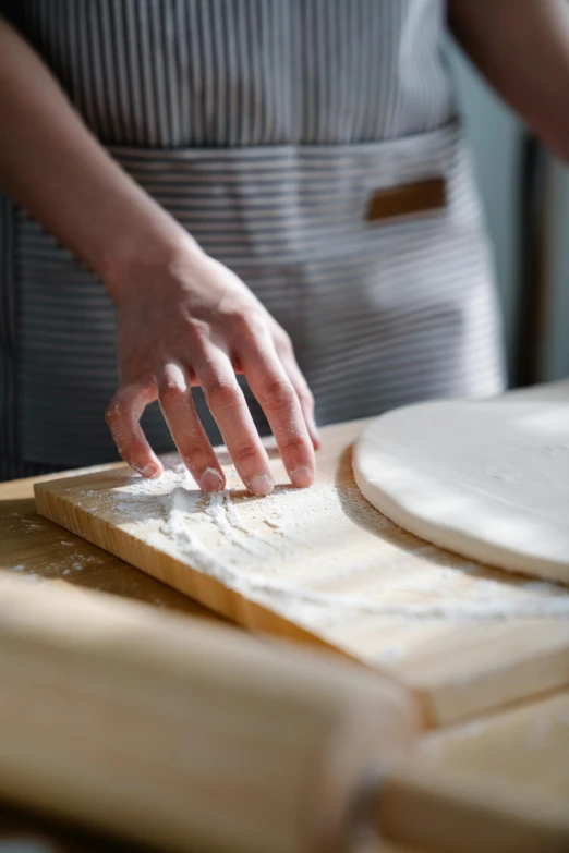 a person kneads dough on a wooden board, by Matthias Stom, trending on unsplash, thin porcelain, arcs, kek, close up portrait shot