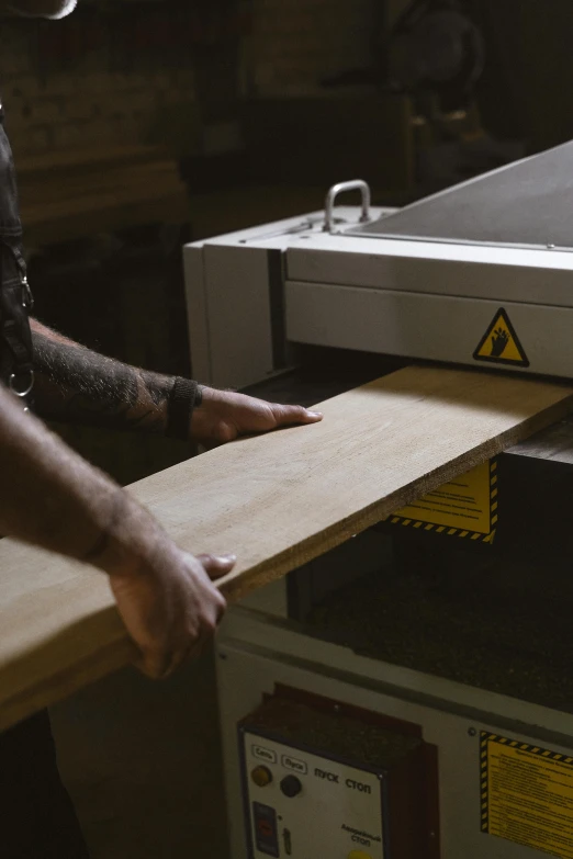 a man using a table saw to cut a piece of wood, a photocopy, unsplash, private press, animation still, 3 / 4 wide shot, bespoke, a gigantic