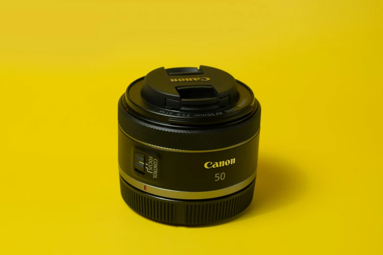 a close up of a camera lens on a yellow background, by David Simpson, unsplash, photorealism, canon eos m50, product photography, shot with a canon 20mm lens, on grey background