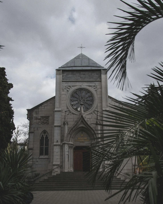 a church with a clock on the front of it, an album cover, unsplash, reunion island, ominous photo, with lots of vegetation, new orleans
