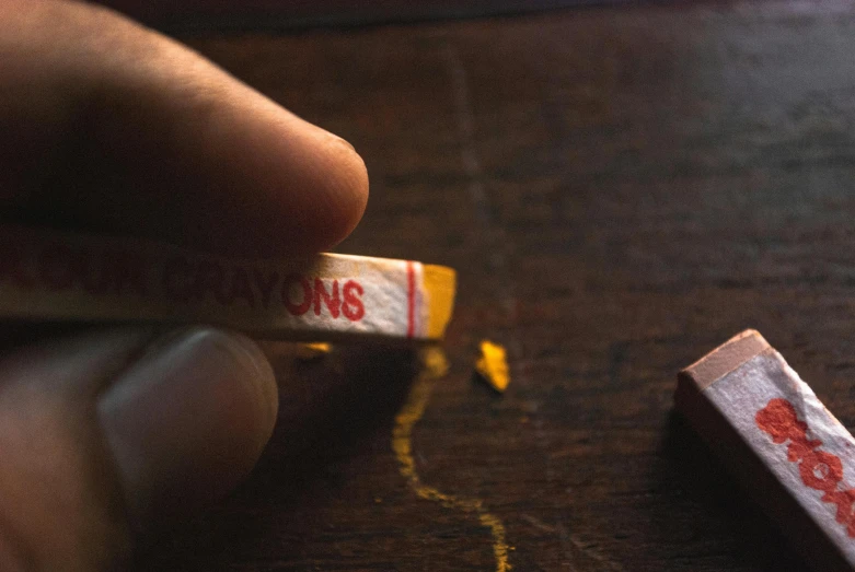 a close up of a person holding a cigarette, a photorealistic painting, pexels contest winner, crayons, faded red and yelow, 3 5 mm kodachrome, crafting