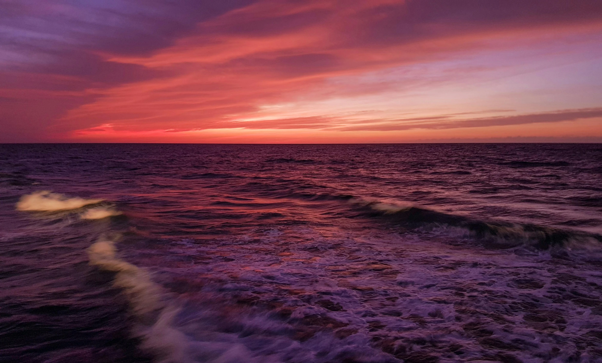 a pink and purple sunset over the ocean, by Carey Morris, pexels contest winner, romanticism, red water, swirling, rhode island, horizon