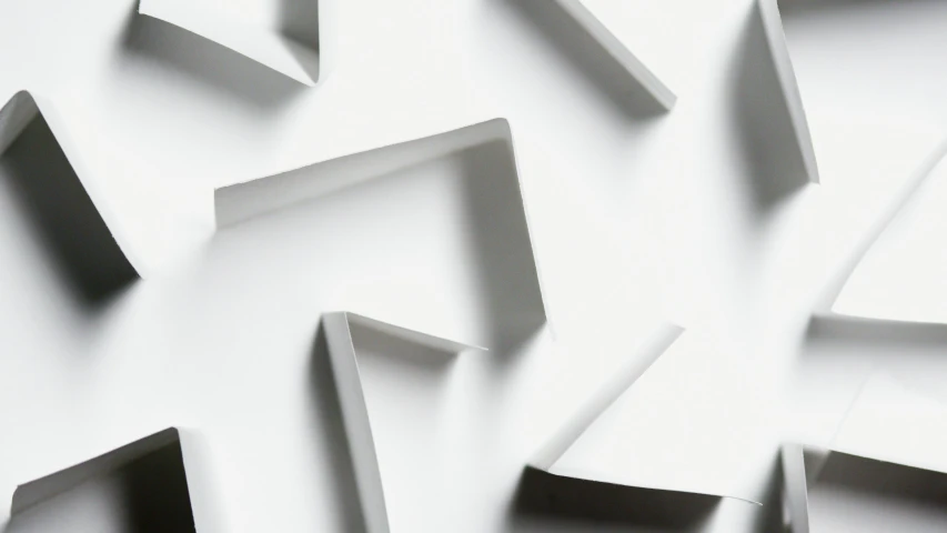 a bunch of pieces of paper sitting on top of a table, inspired by Rachel Whiteread, unsplash, abstract illusionism, white background with shadows, zig zag, dynamic angled shot, white ceramic shapes