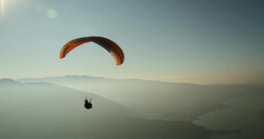 a person that is flying in the air with a parachute, pexels contest winner, hurufiyya, overlooking a valley, subtle detailing, back - lit, nepal